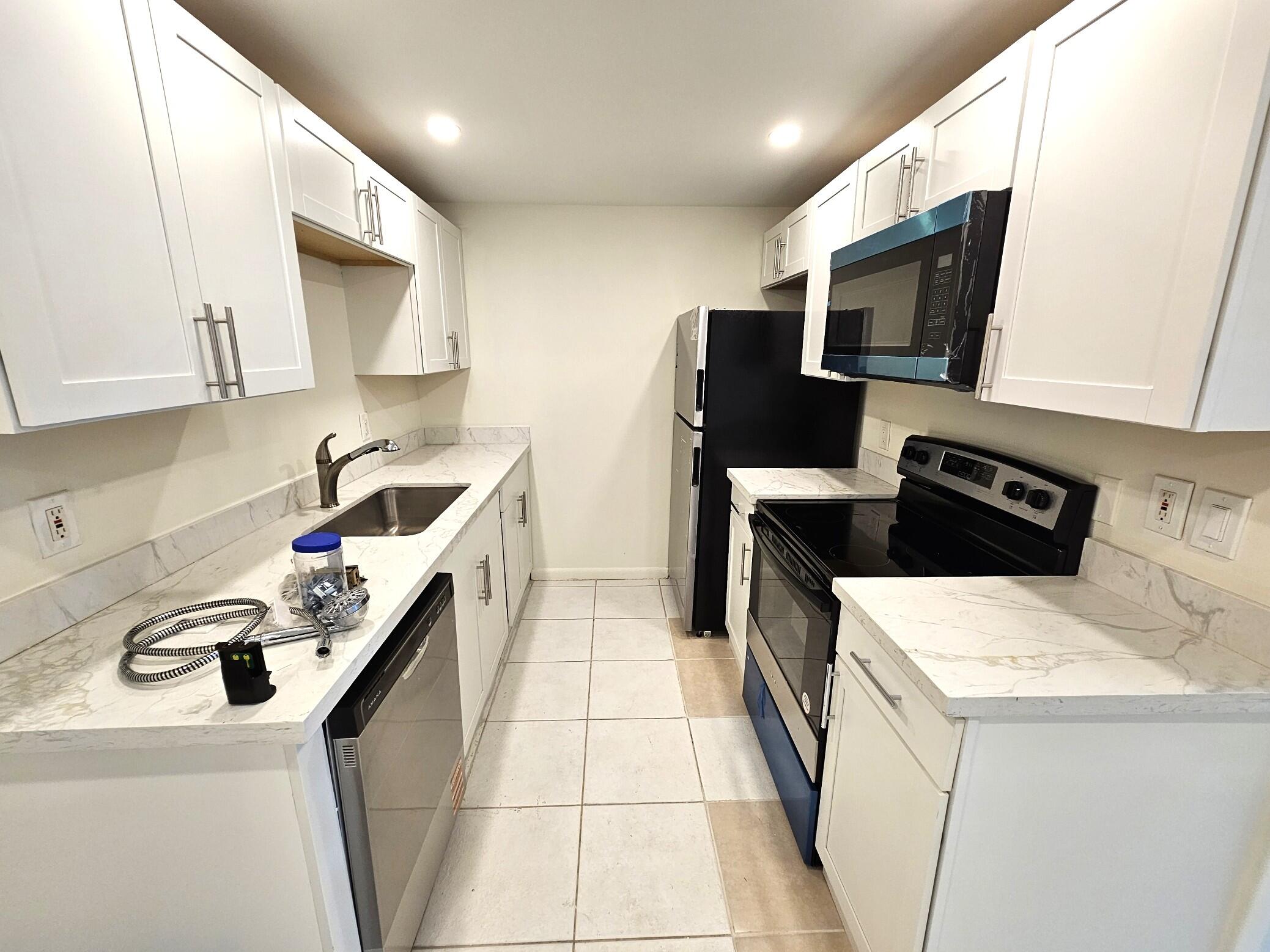 1059 Ainslie Drive, Unit 1059 Boca Raton, FL 33434 - Photo 9 of 15 a kitchen that has a sink and a stove in it