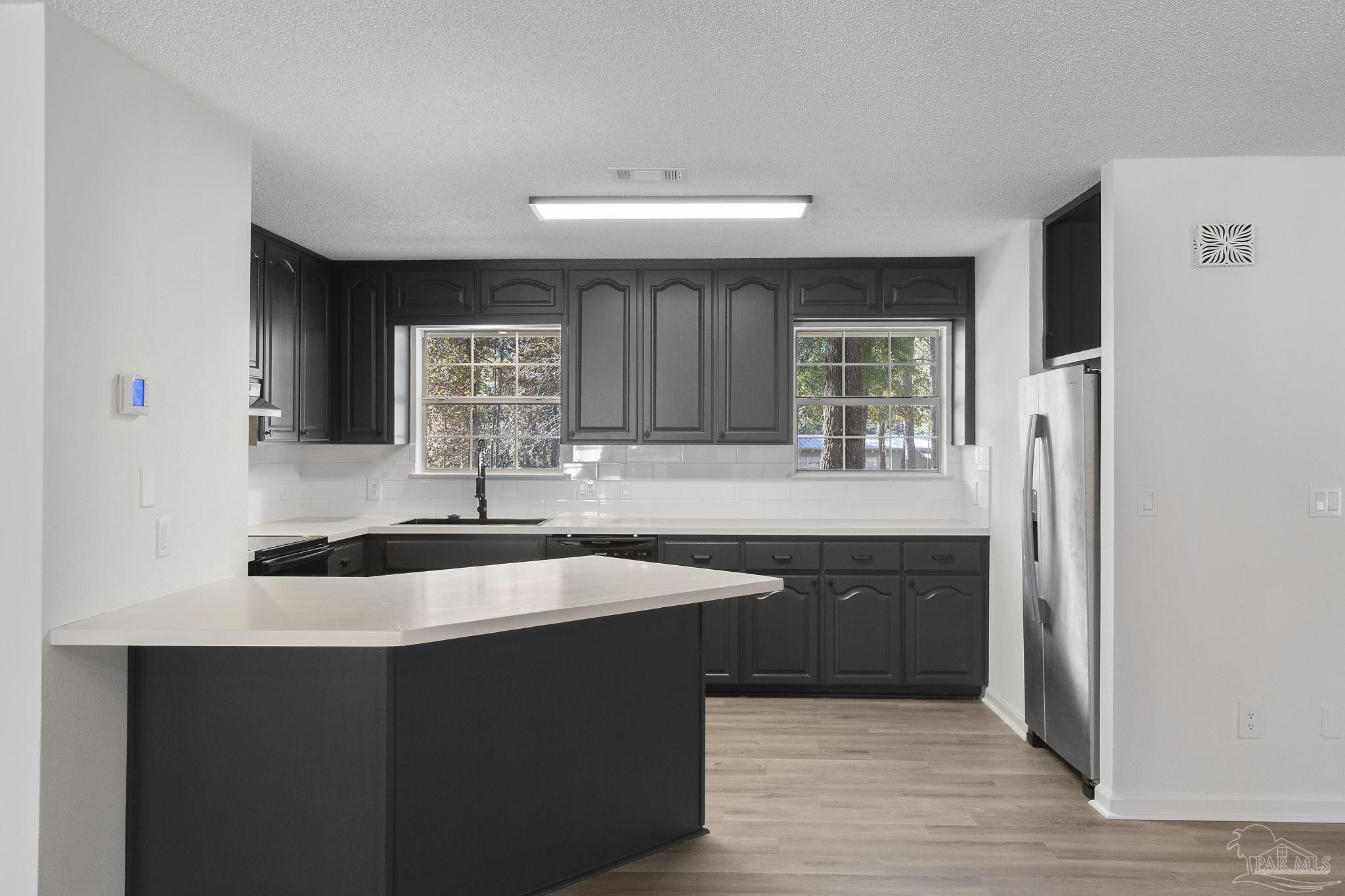 195 Miller Road DeFuniak Springs, FL 32435 - Photo 11 of 50 a kitchen with stainless steel appliances granite countertop a sink stove and refrigerator