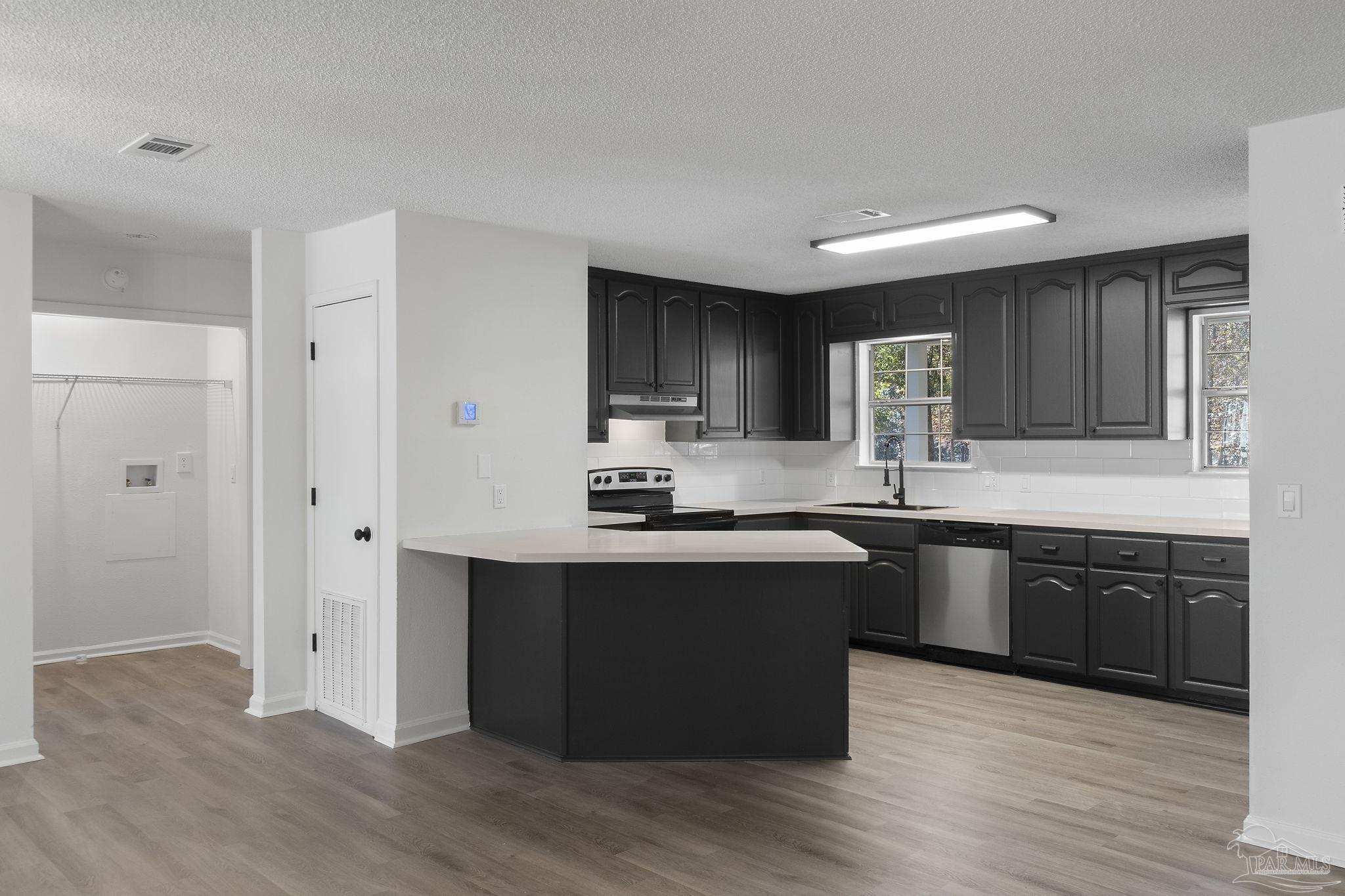 195 Miller Road DeFuniak Springs, FL 32435 - Photo 13 of 50 a kitchen with stainless steel appliances granite countertop a sink stove and refrigerator