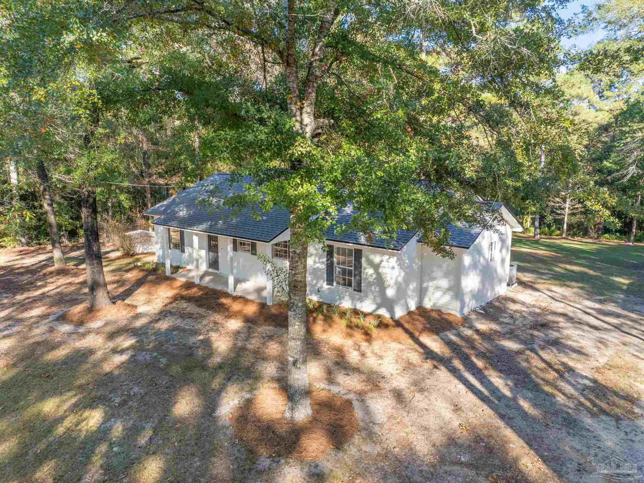 195 Miller Road DeFuniak Springs, FL 32435 - Photo 40 of 50 a view of backyard with a table and chairs under an umbrella