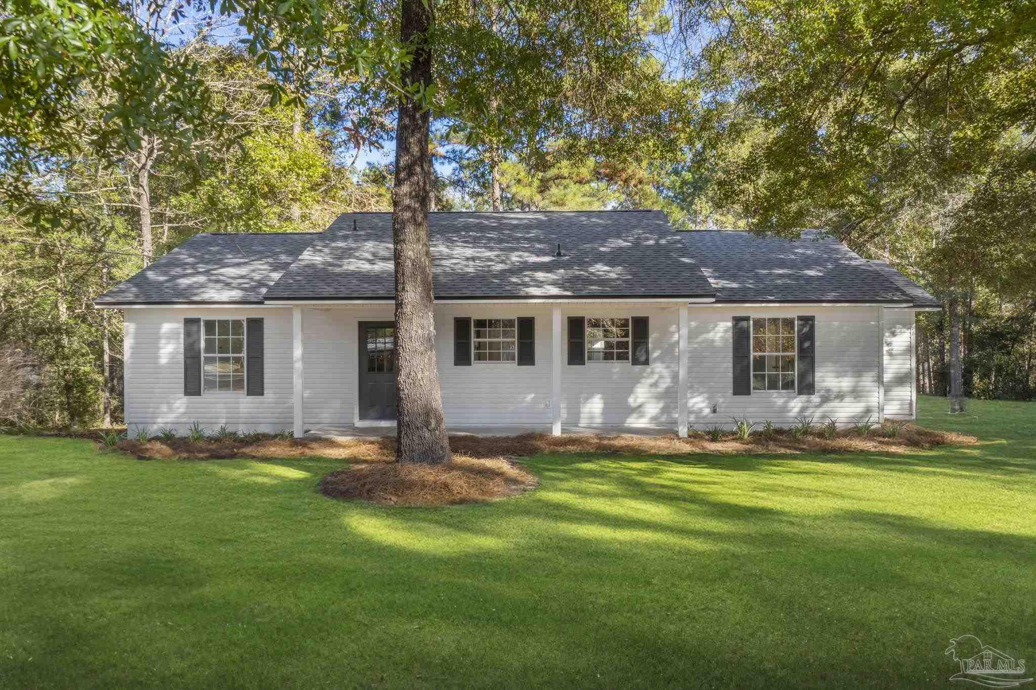 195 Miller Road DeFuniak Springs, FL 32435 - Photo 49 of 50 a front view of a house with a garden and trees