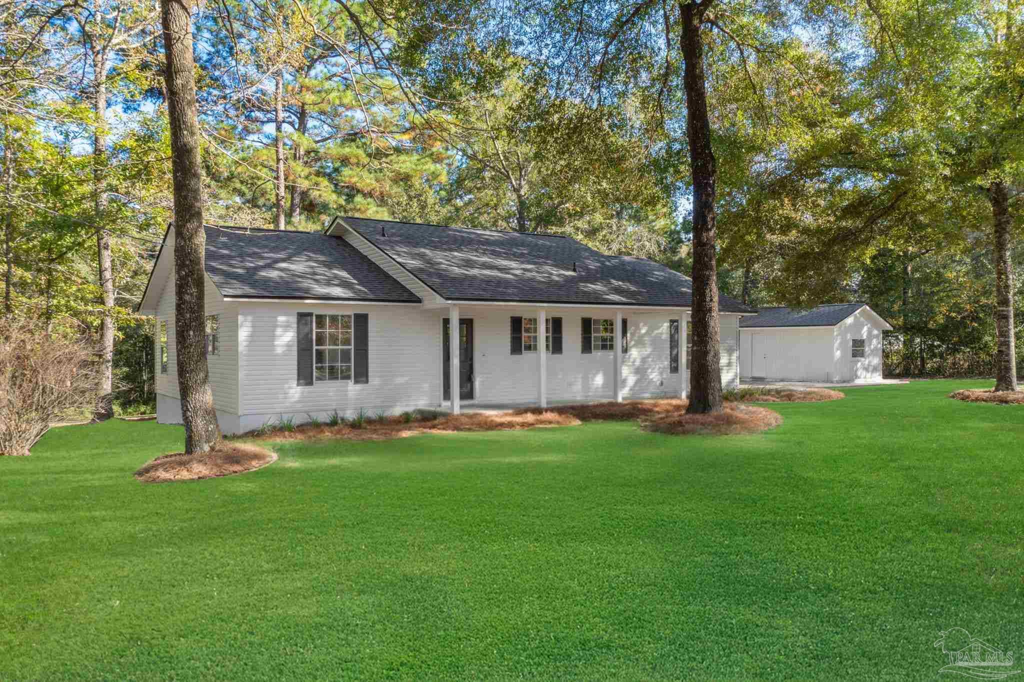 195 Miller Road DeFuniak Springs, FL 32435 - Photo 50 of 50 a front view of a house with a garden and trees