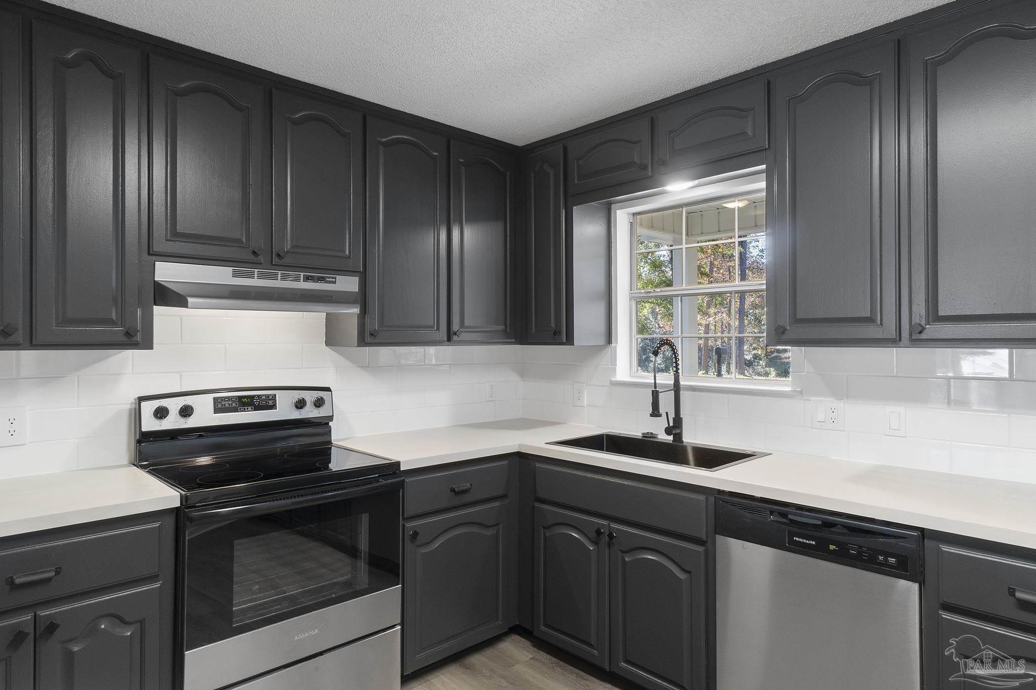 195 Miller Road DeFuniak Springs, FL 32435 - Photo 9 of 50 a kitchen with granite countertop wood cabinets stainless steel appliances and a sink