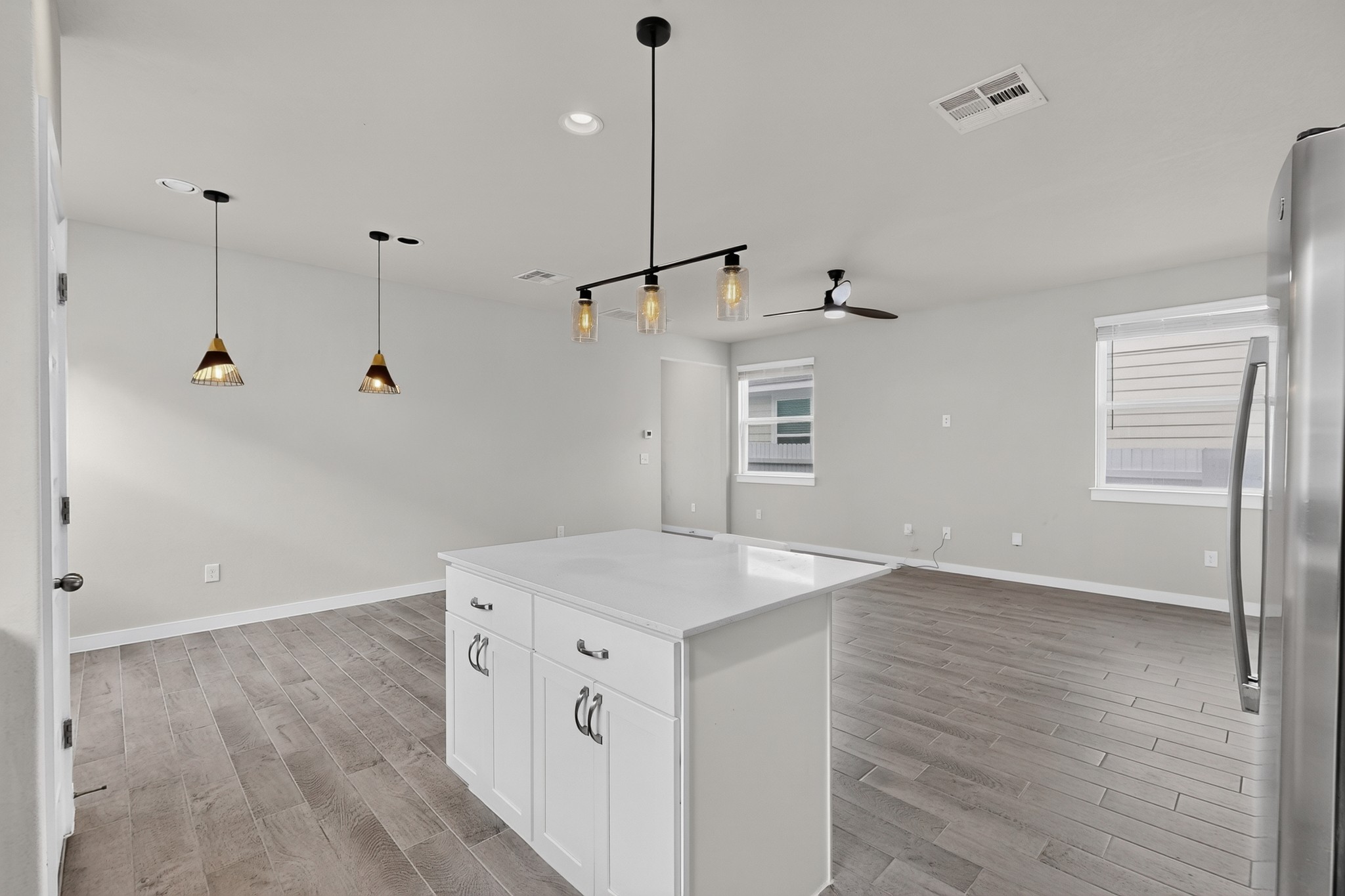 116 Appleberry Lane Elgin, TX 78621 - Photo 11 of 35 A well-lit, open-concept living area features a bright kitchen island and contemporary flooring.