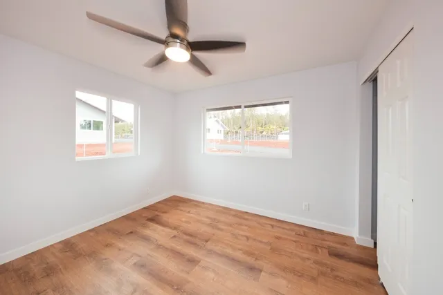 an empty room with windows and fan