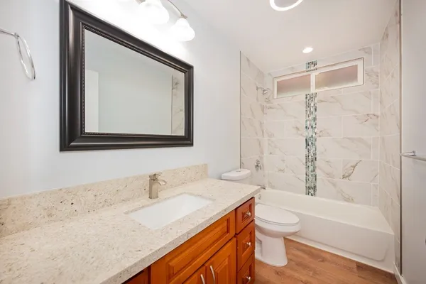 a bathroom with a granite countertop sink toilet and shower