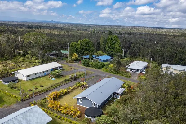 an aerial view of a house with swimming pool and mountains