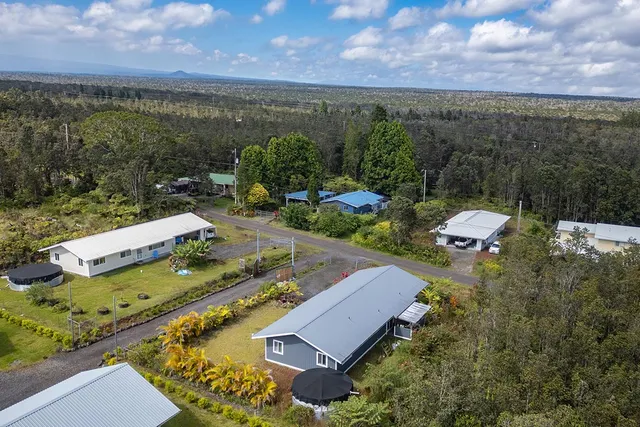 an aerial view of a house with swimming pool and mountains