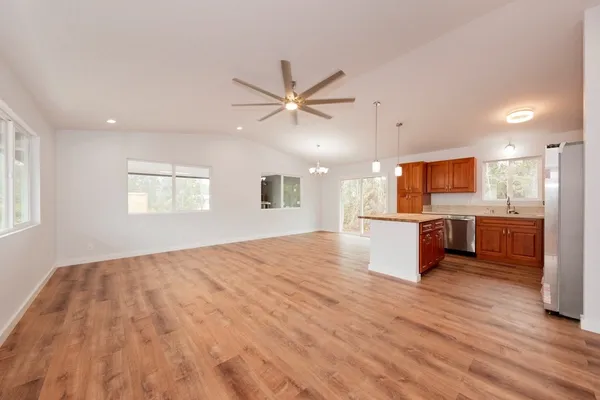 a view of a kitchen with kitchen island a sink stainless steel appliances and cabinets