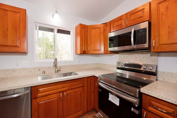 a kitchen with stainless steel appliances granite countertop a sink stove and microwave