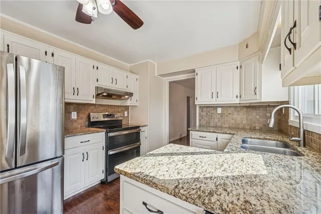 a kitchen with stainless steel appliances granite countertop a refrigerator sink and stove