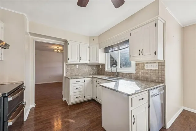 a kitchen with granite countertop a sink stainless steel appliances and cabinets