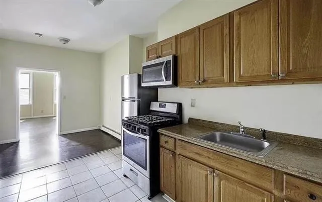 a kitchen with stainless steel appliances granite countertop a sink stove and cabinets