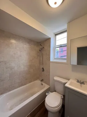 a bathroom with a toilet a sink a mirror and a bathtub