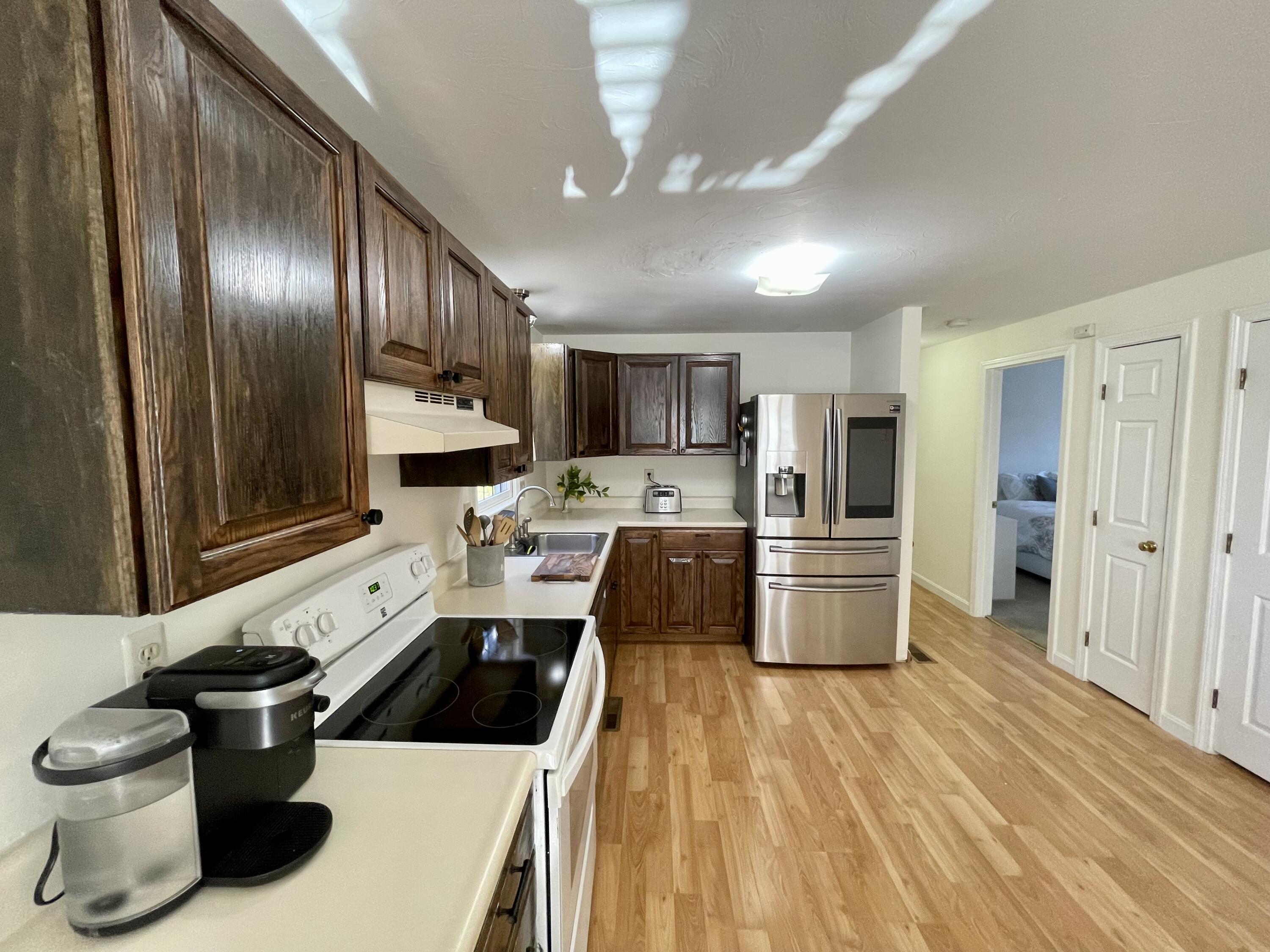 97 Braley Jenkins Road Centerville, MA 02632 - Photo 18 of 39 a kitchen with a refrigerator a stove a sink and dishwasher with wooden floor