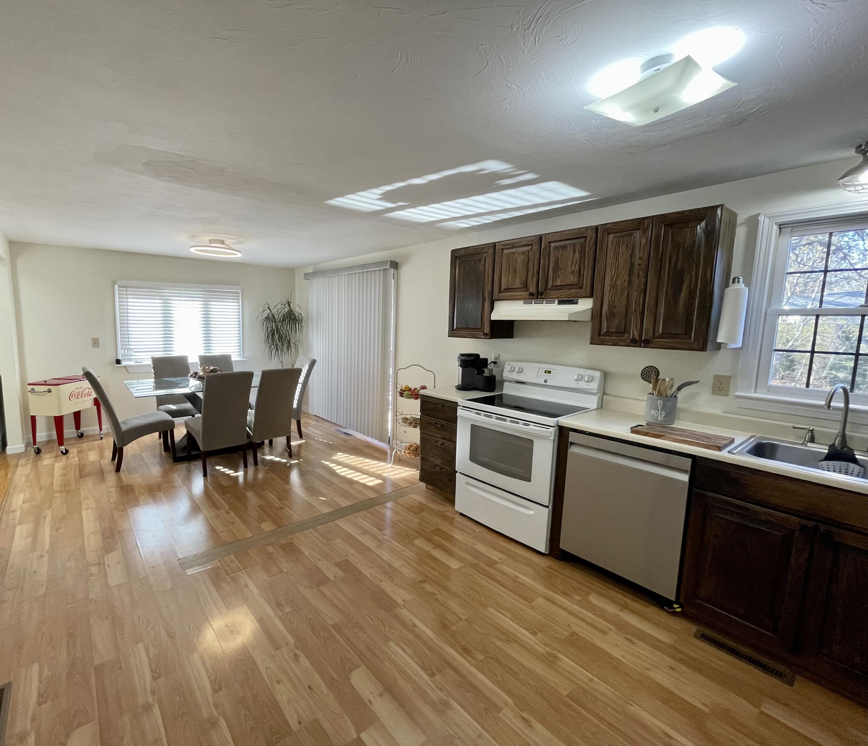 97 Braley Jenkins Road Centerville, MA 02632 - Photo 19 of 39 a kitchen with stainless steel appliances granite countertop a refrigerator a sink dishwasher a stove and white countertops with wooden floor
