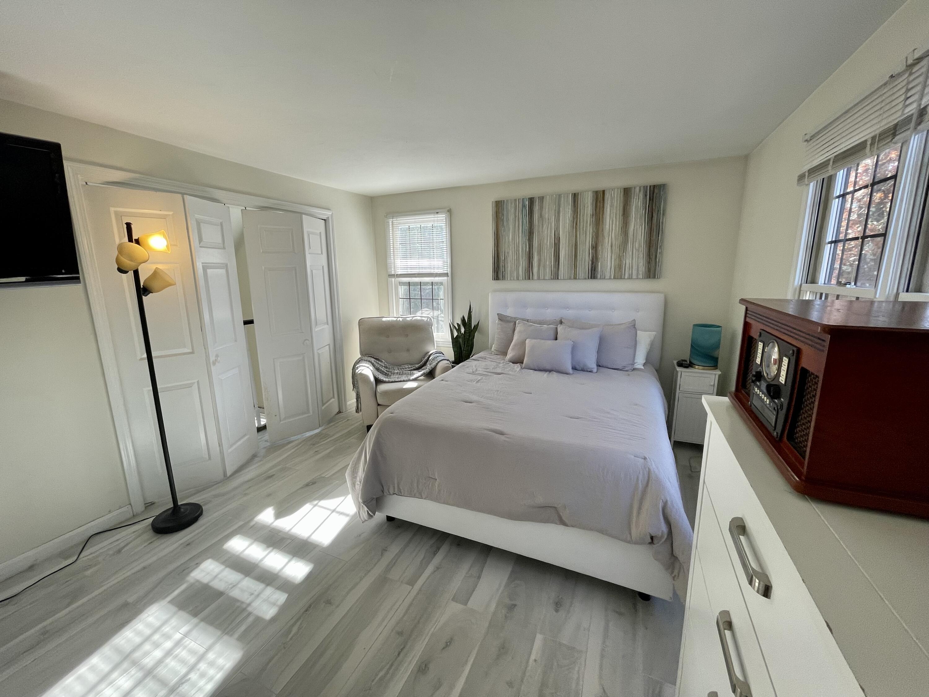 97 Braley Jenkins Road Centerville, MA 02632 - Photo 29 of 39 a bedroom with a bed a mirror on dresser and a window