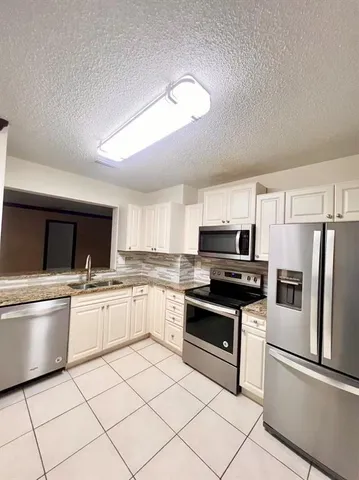 a kitchen with granite countertop appliances cabinets and a sink