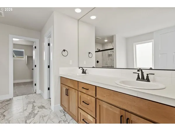 a bathroom with double vanity sinks and a shower