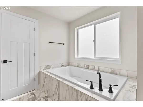 a bathroom with a tub sink and mirror