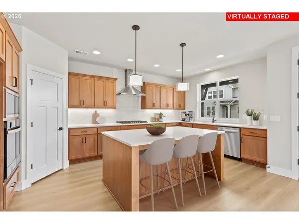 a kitchen with kitchen island granite countertop a sink cabinets and stainless steel appliances