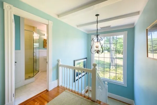 a view of a room with window wooden floor and front door