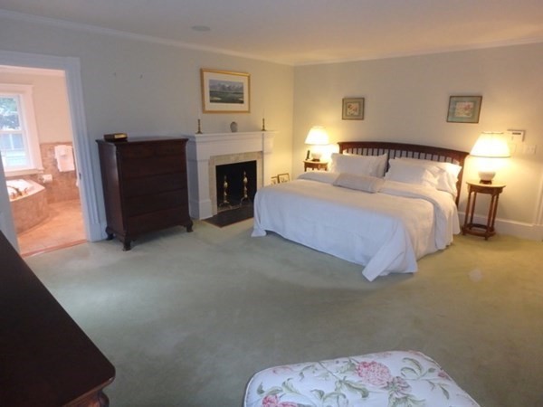 31 Lamberts Cove Road Tisbury, MA 02568 - Photo 18 of 35 a spacious bedroom with a bed and a fireplace