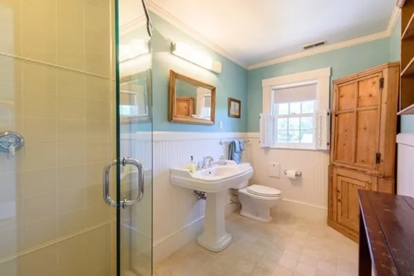 a bathroom with a sink a toilet and shower