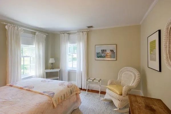 a bedroom with a bed chair and a window