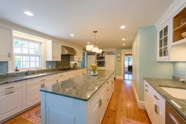 a large kitchen with kitchen island a large island in it
