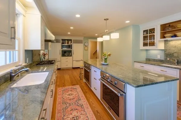 a bathroom with a granite countertop sink and a large mirror