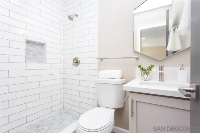 a bathroom with a sink a toilet and mirror
