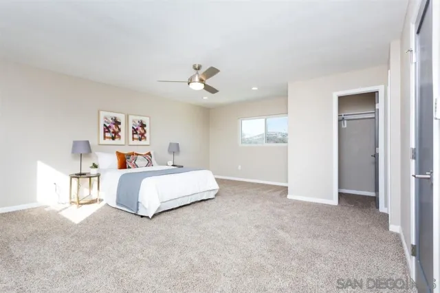 a spacious bedroom with a bed and a chandelier