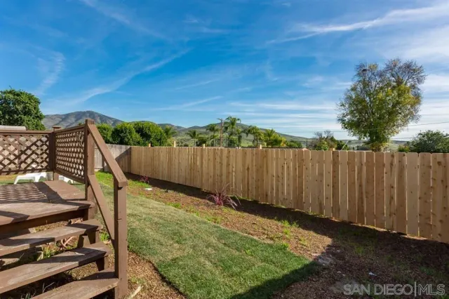 a view of a backyard with wooden fence