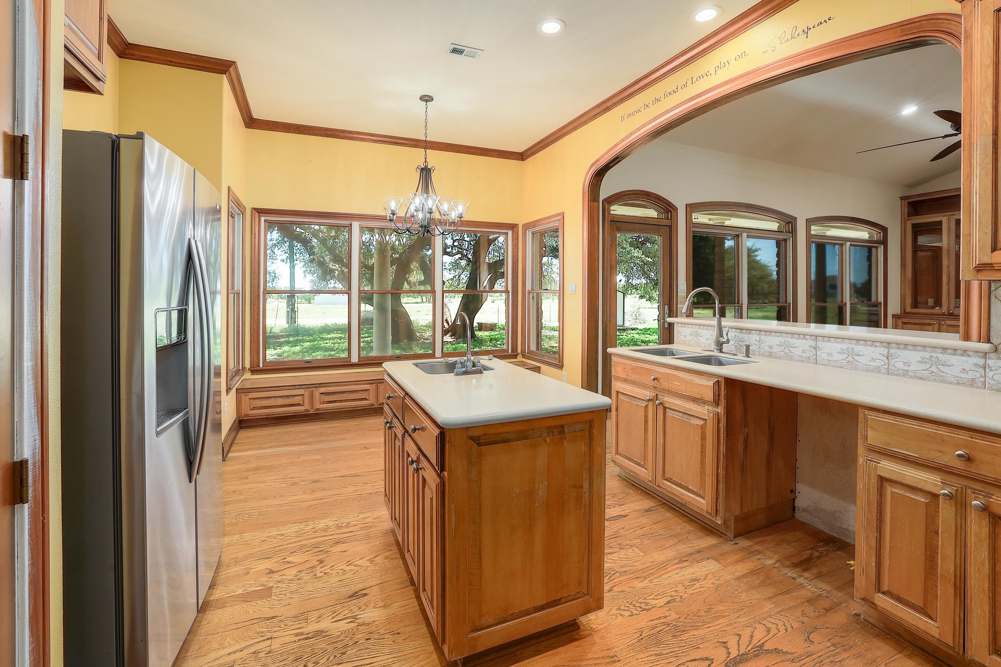 3900 Shell Road Georgetown, TX 78628 - Photo 12 of 40 Kitchen with stainless steel refrigerator with ice dispenser, light wood-style floors, hanging light fixtures, light countertops, and ornamental molding