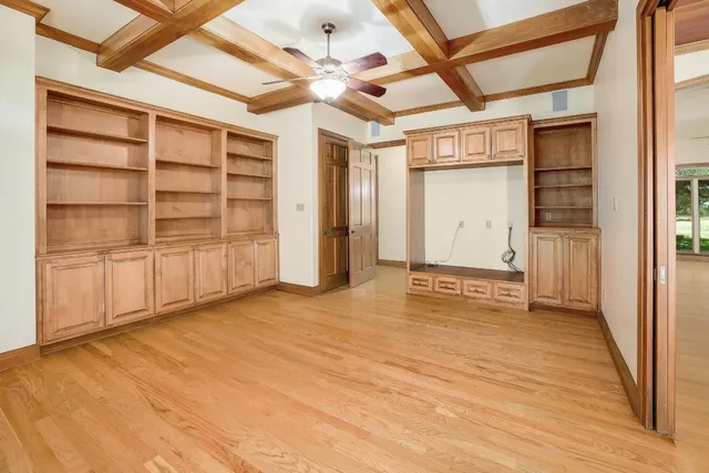 an empty room with cabinet and windows