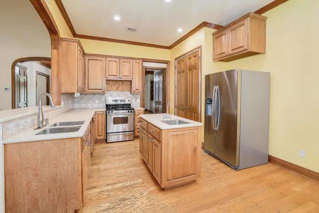 a kitchen with stainless steel appliances granite countertop a sink stove and refrigerator