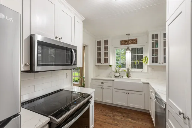 a kitchen with white cabinets and window