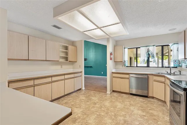 a large white kitchen with sink stove and refrigerator