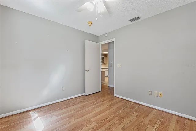 an empty room with windows and fan