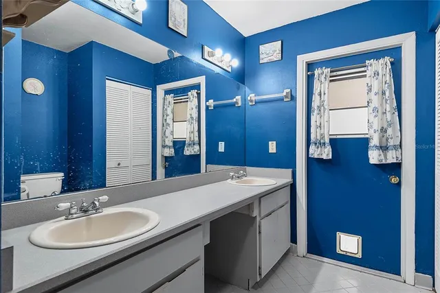an empty room with wooden floor chandelier fan and windows