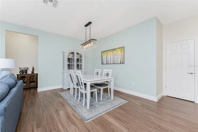 a dining room with furniture a chandelier and wooden floor
