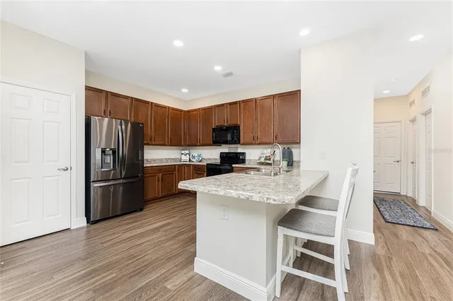 a kitchen with stainless steel appliances granite countertop a refrigerator stove microwave and sink