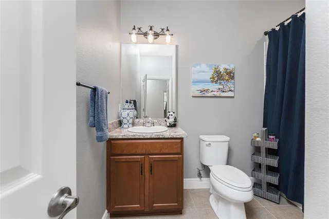 a bathroom with a toilet and a shower curtain