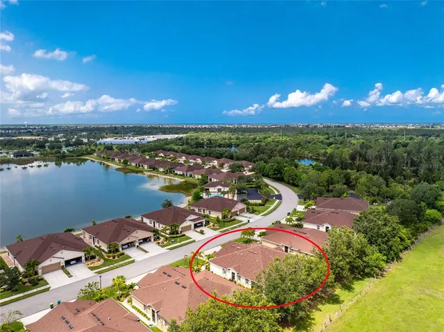 an aerial view of lake and residential houses with outdoor space