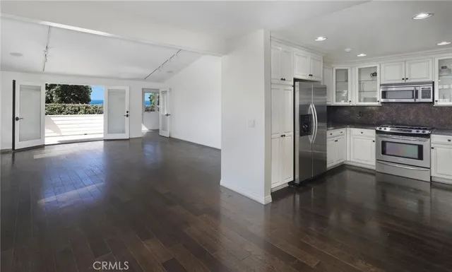 a kitchen with a refrigerator and a stove top oven
