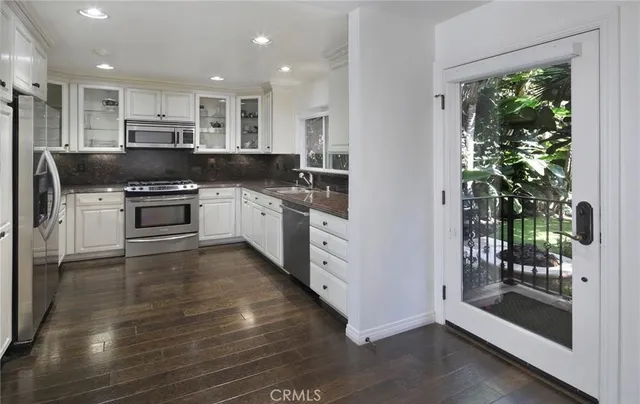 a large kitchen with stainless steel appliances granite countertop a stove and a refrigerator