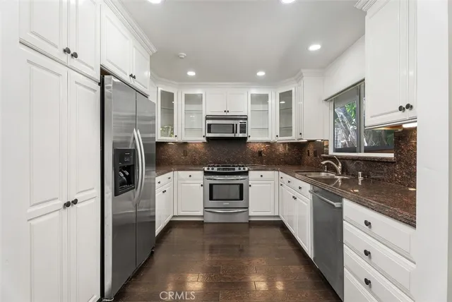 a kitchen with stainless steel appliances granite countertop a refrigerator stove and sink
