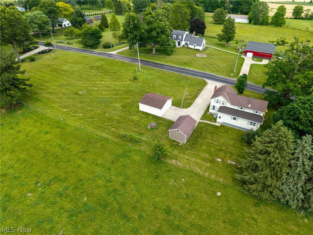 9626 Daniels Road Seville, OH 44273 - Photo 4 of 37 Expansive green acreage featuring a main residence, two outbuildings, a detached garage, and a paved driveway