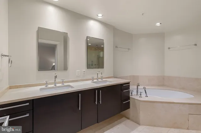 a bathroom with double vanity sinks and a bathtub